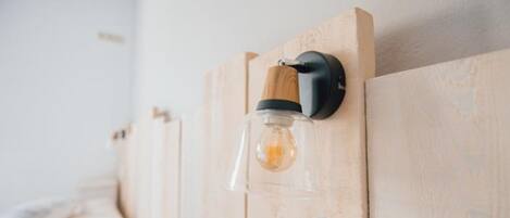 Cabecera de madera con lámpara de pared y un interruptor.