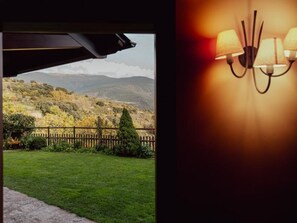 Habitación con vista a un área verde y montañas.