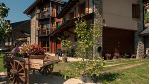 Ein mehrstöckiges Gebäude mit Stein-Fassade, Balkonen und einer überdachten Außenbereich-Sitzgelegenheit.