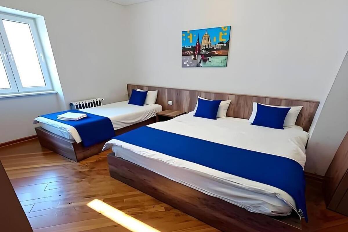 Habitació d'hotel amb dos llits, un quadre a la paret i una finestra.