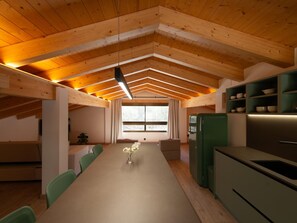 Une cuisine moderne dotée d’un long plan de travail, de meubles de couleur verte et d’une fenêtre laissant entrer la lumière naturelle.