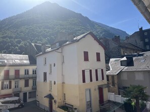 A building with a white facade, red shutters, and a balcony. - Cozy apartment in the heart of Cauterets - 4 guests (Cauterets)