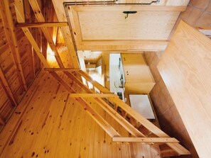 A wooden interior with a staircase, a white cabinet, and a wooden wall.