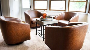A room with four brown leather chairs, a small wooden table with a tray, and a window with blinds. - Inviting Lakefront Escape with Modern Comforts & High‑Speed Fiber (Edgerton)