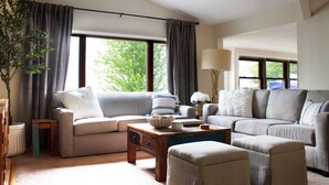 A living room with two sofas, a coffee table, and a lamp. - Inviting Lakefront Escape with Modern Comforts & High‑Speed Fiber (Edgerton)