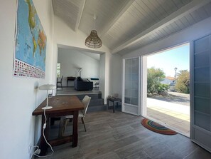 A modern interior with a dining area, a sofa, a map on the wall, and a view through a glass door. - Welcoming house near the beach - 6 guests (L'Épine)