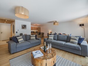 A modern living room with two grey sofas, a wooden coffee table, and a dining area in the background. - Quiet apartment in Argentière center - 6 guests (Argentière)