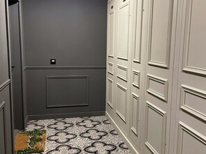 A narrow hallway with grey walls, a patterned floor, and a door with a small label. - Quiet apartment in Argentière center - 6 guests (Argentière)