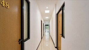 A corridor with doors numbered 48 and 45, leading to rooms. - Collection O near Cihampelas Walk former (Bandung)
