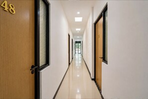 Passadís amb portes numerades 48 i 45, que condueixen a habitacions.