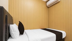 A single bed with a white mattress, two pillows, a black accent pillow, and a dark-colored headboard. - Collection O near Cihampelas Walk former (Bandung)