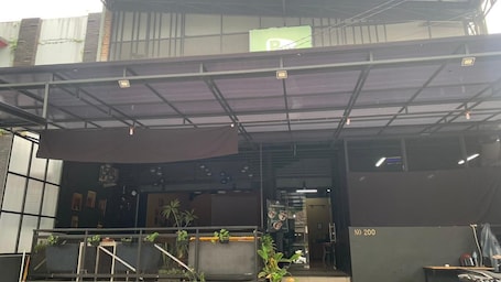 An industrial-style building with a covered entrance, metal railings, and a sign indicating a parking area.. Collection O near Cihampelas Walk former