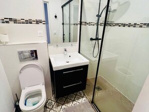 Un baño con inodoro, lavabo y ducha.