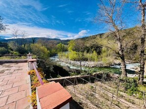 Une vue sur la rivière, avec un pont, des arbres et un ciel dégagé.