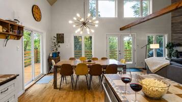 A spacious dining area with a wooden table, chairs, and a large window providing a view of the outdoors.