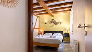 A bedroom with a bed, a nightstand, a lamp, and a wall-mounted decorative piece.
