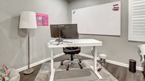 Ein Arbeitsplatz mit Schreibtisch, Computer und Stuhl.