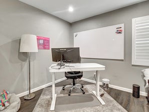Ein Arbeitsplatz mit Schreibtisch, Computer und Stuhl.