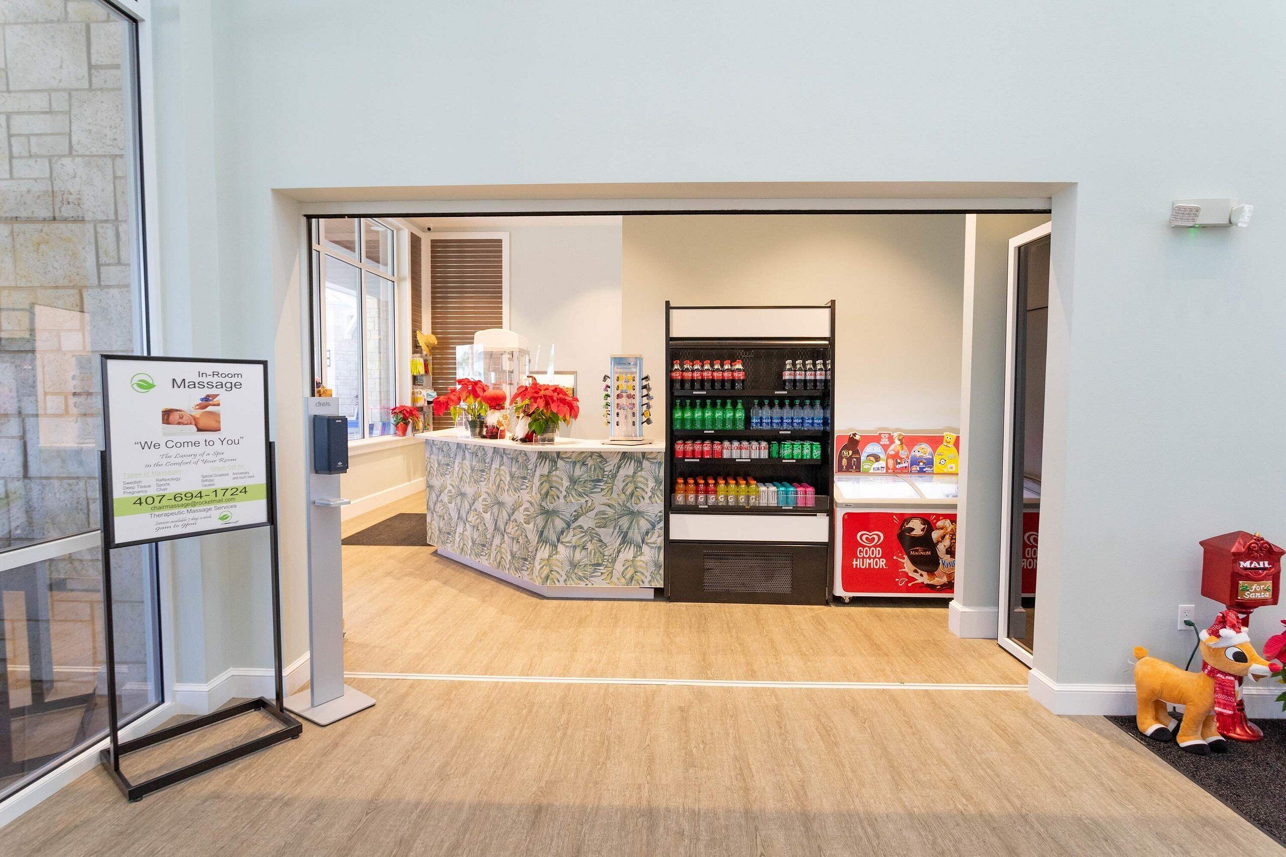 A reception area with a reception desk, a display of bottled water, and a small gift shop.