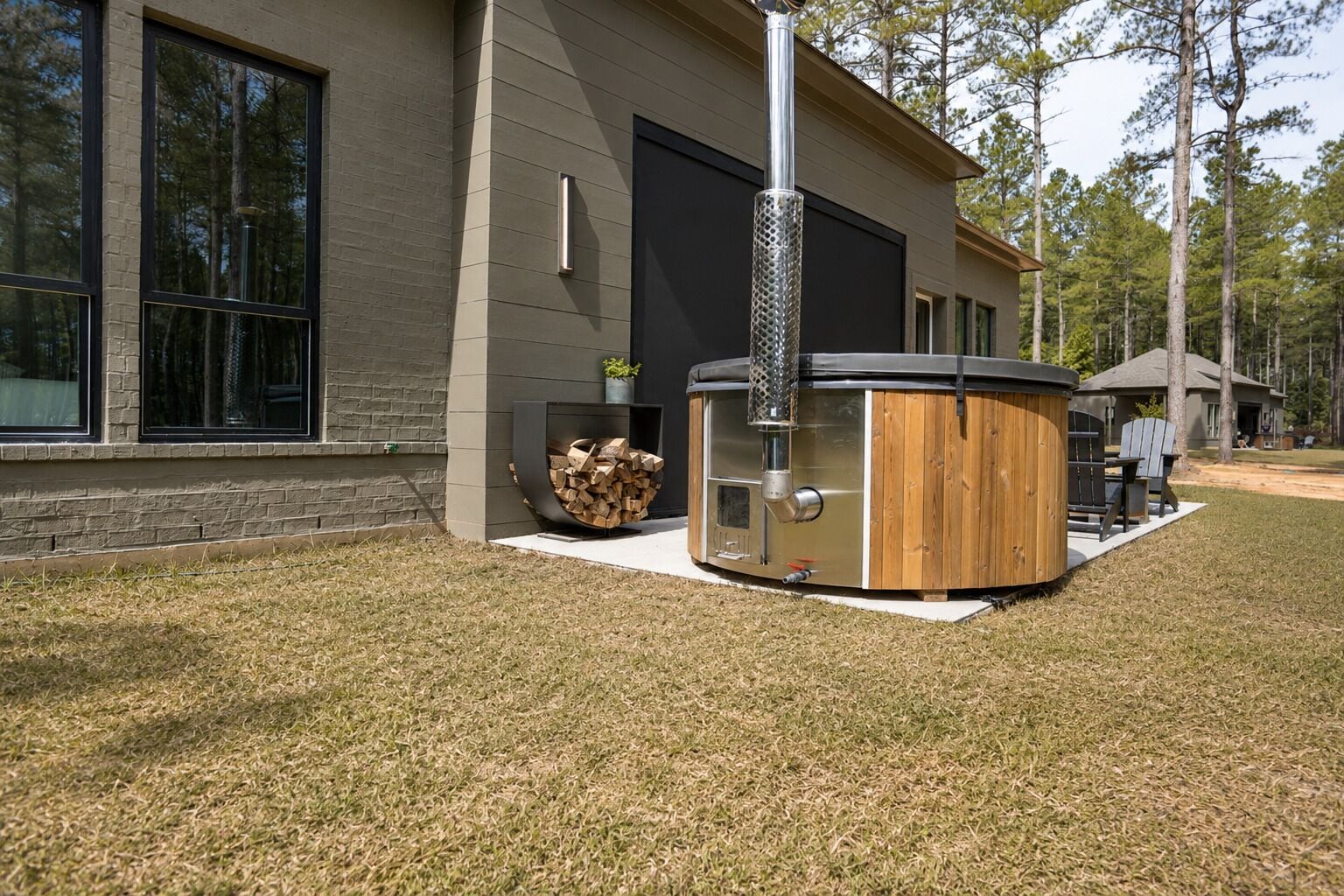 A modern building with large windows, a hot tub, and a fire pit.