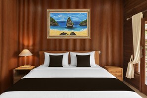 Habitación de hotel con cama, mesita de noche, lámpara, un cuadro de una playa y una ventana con cortinas.