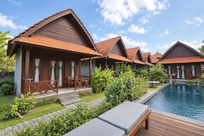A resort with multiple wooden villas, a swimming pool, and lush greenery. - Belvilla near Sampalan Beach formerly Ar (Penida Island)