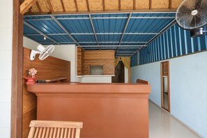 A reception area with a wooden reception desk, a blue ceiling, and a fan. - Belvilla near Sampalan Beach formerly Ar (Penida Island)