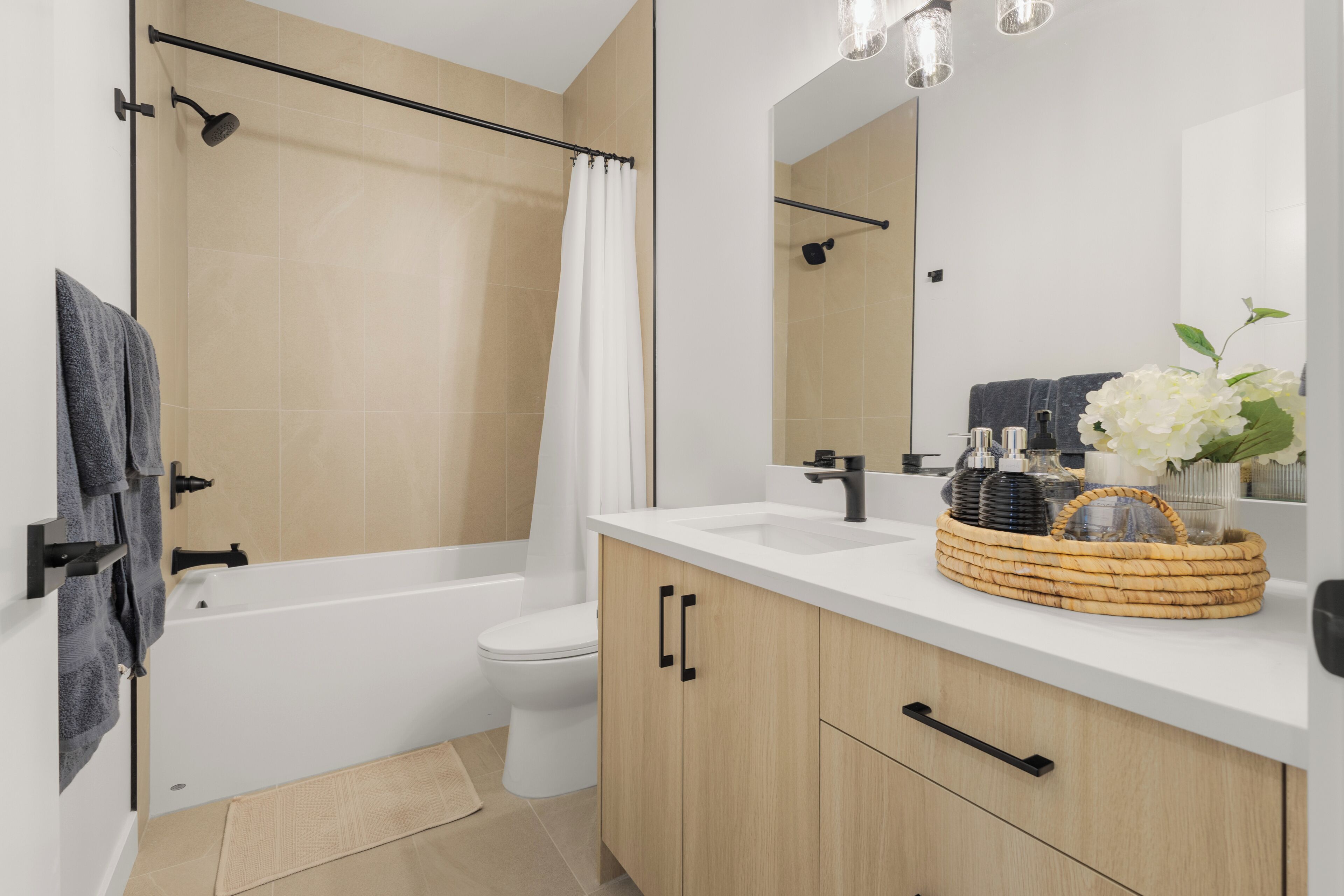 Een moderne badkamer met een badkuip, toilet en wastafel.