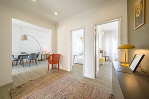 Ein modernes Hotelzimmer mit Essbereich, einem großen Teppich und einem Bett.
