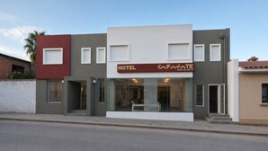 A modern hotel with a flat facade, large windows, and a prominent sign.