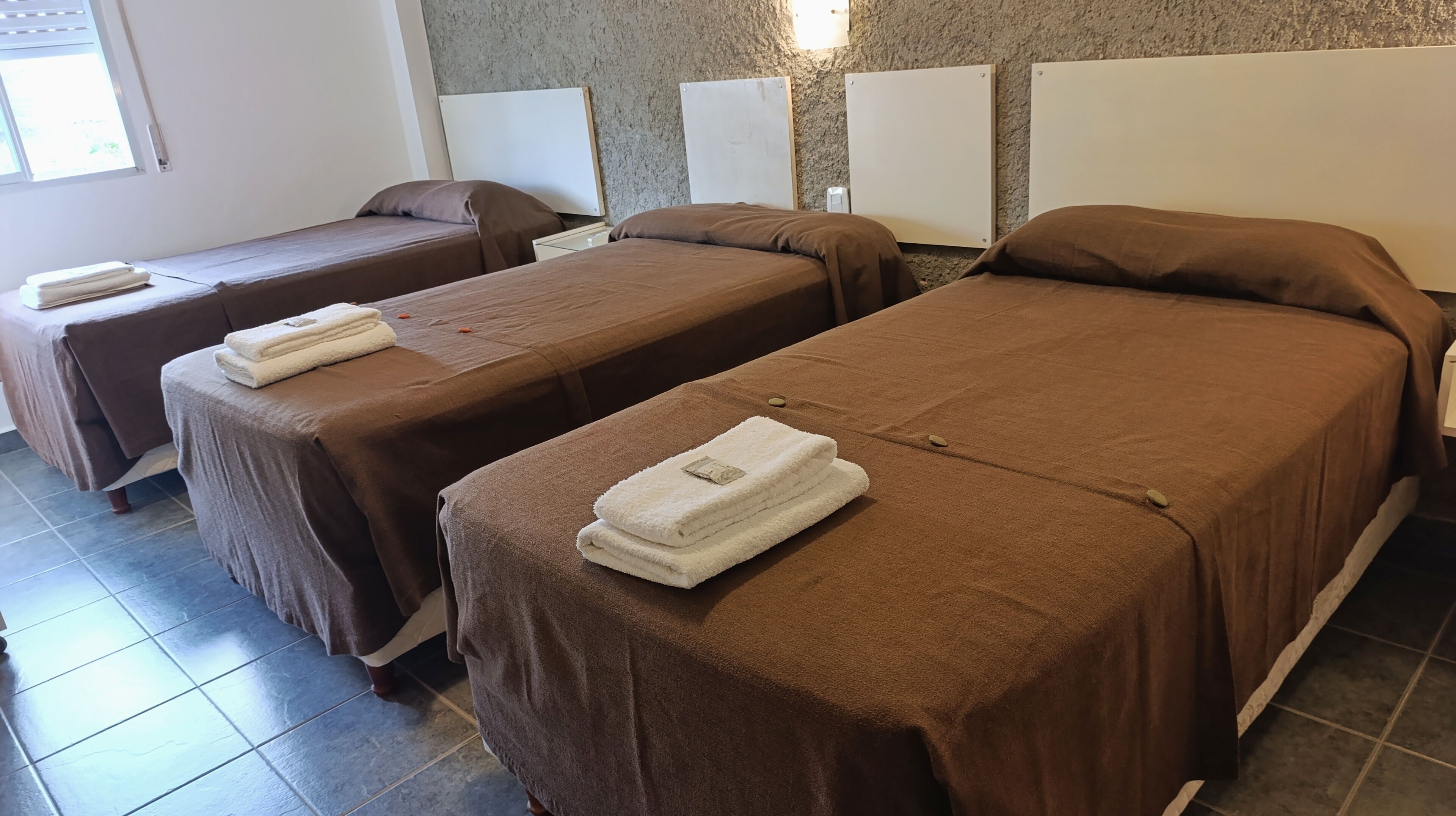 Ett hotellrum med två separata sängar, var och en med ett brunt överkast och vita handdukar.