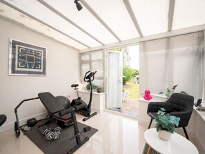 A home gym with exercise equipment, a chair, and a potted plant. - Stylish House - 25mins London Bridge train journey - Pass the Keys (London)