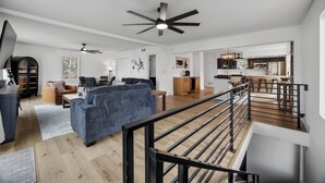 Een modern interieur met een zithoek, keuken en trap.
