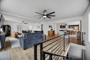 A modern interior with a living area, kitchen, and staircase. - Osage Beach - Main Channel Views & Cove Protection (Osage Beach)