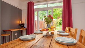 Une table à manger avec des assiettes, un centre de table composé de fruits et une bougie.