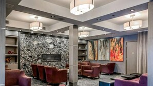 Una hall moderna con zone relax, un camino e opere d'arte alle pareti.
