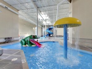 An indoor swimming pool with a water slide and a frog-shaped play area. - Three Sisters Vista - Hot Tub, Pool & Waterslide (Canmore)