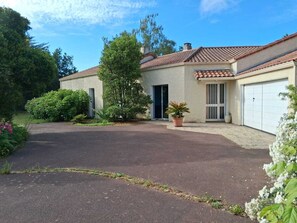 A single-story house with a tiled roof, a garage, and a driveway leading to the entrance. - Family home in the heart of the Nantes vineyards (Vertou)