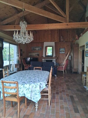 A rustic dining area with a chandelier, wooden beams, and a tiled floor. - Family home in the heart of the Nantes vineyards (Vertou)
