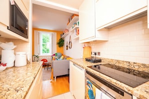 Una cocina moderna con encimeras de granito, horno empotrado y microondas.