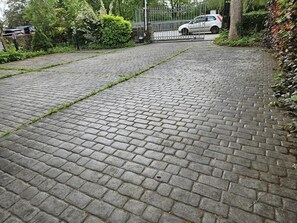 A paved pathway leading to a gated entrance with a parked car. - Charming 4-bedroom Holiday Home in Chorley (Chorley)