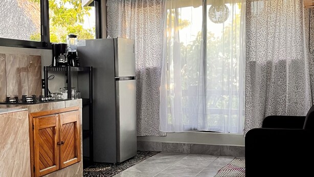 Una cucina con frigorifero, macchina del caffè e mobili in legno.