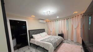 Ein Schlafzimmer mit einem Bett, einem Marmorboden, einem rosa Teppich und einer Deckenleuchte.