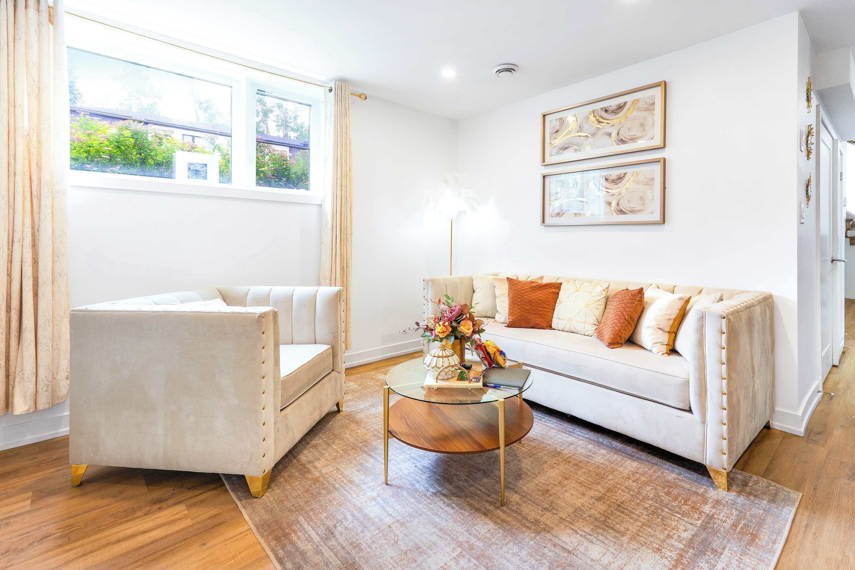 A living room with a sofa, armchair, and a coffee table with decorative items.