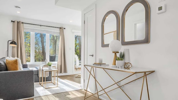 A modern living room with a sofa, a coffee table, and a console table with a mirror. - New 2BR Suite Sleeps 5, 7 Min to Falls w/Parking (Niagara Falls)