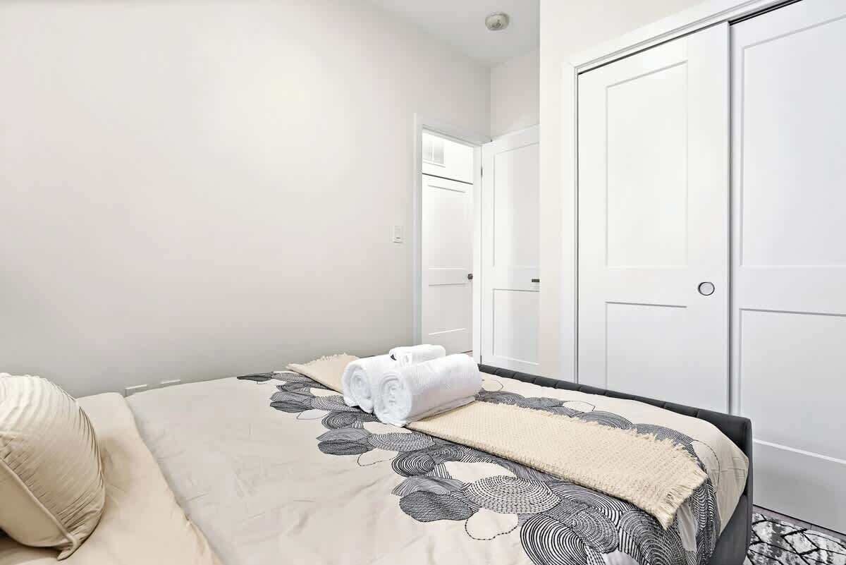 A hotel room with a bed, a white door, and a closet.