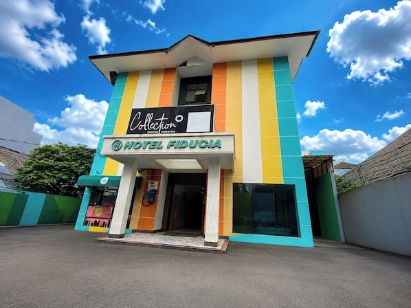 A hotel with a colorful facade, a sign for 'HOTEL FIDUCIIA,' and a visible entrance. - Townhouse Oak New Fiducia Kaji 2 (Jakarta)