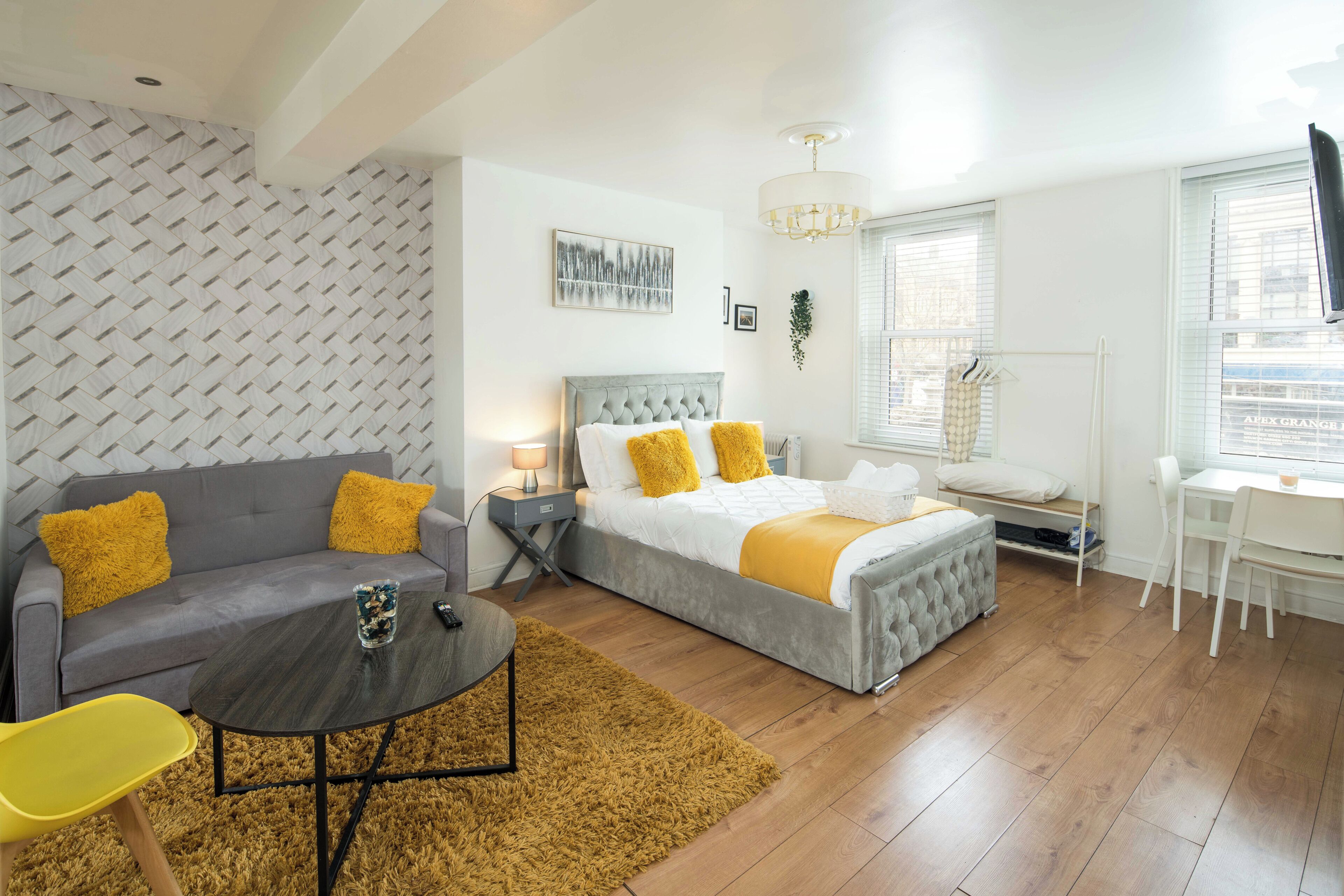 Une chambre moderne avec un lit, un canapé, une petite table et un bureau.