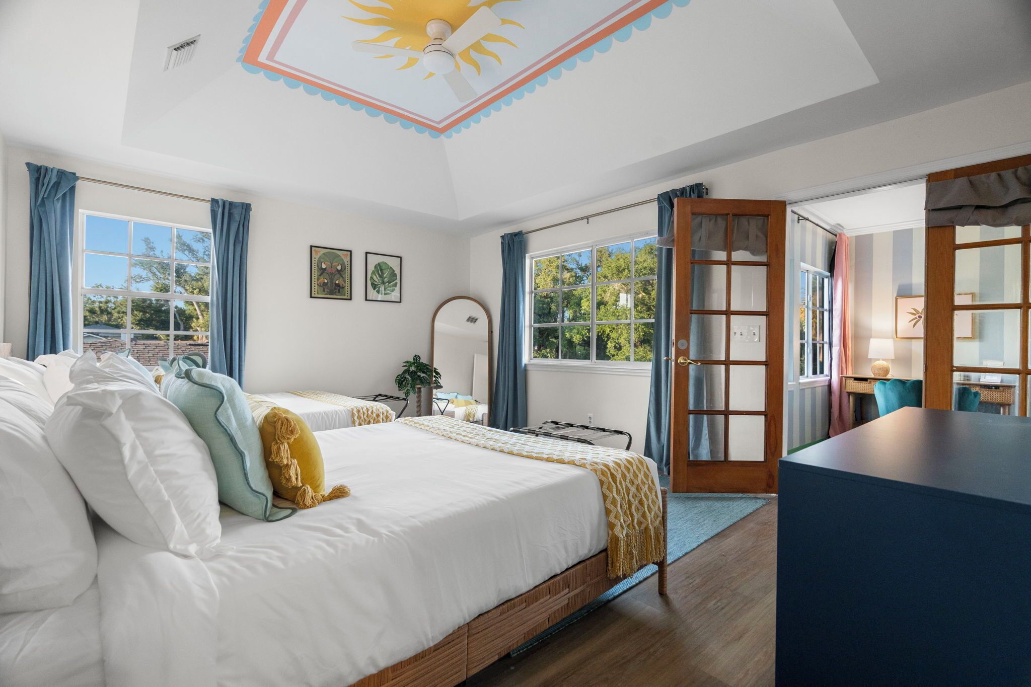 A bedroom with a bed, bedside table, and a view of the outdoors.