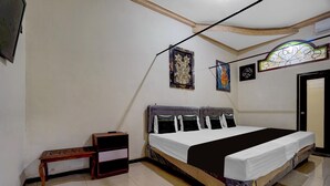 A bedroom with a bed, a nightstand, and a door.